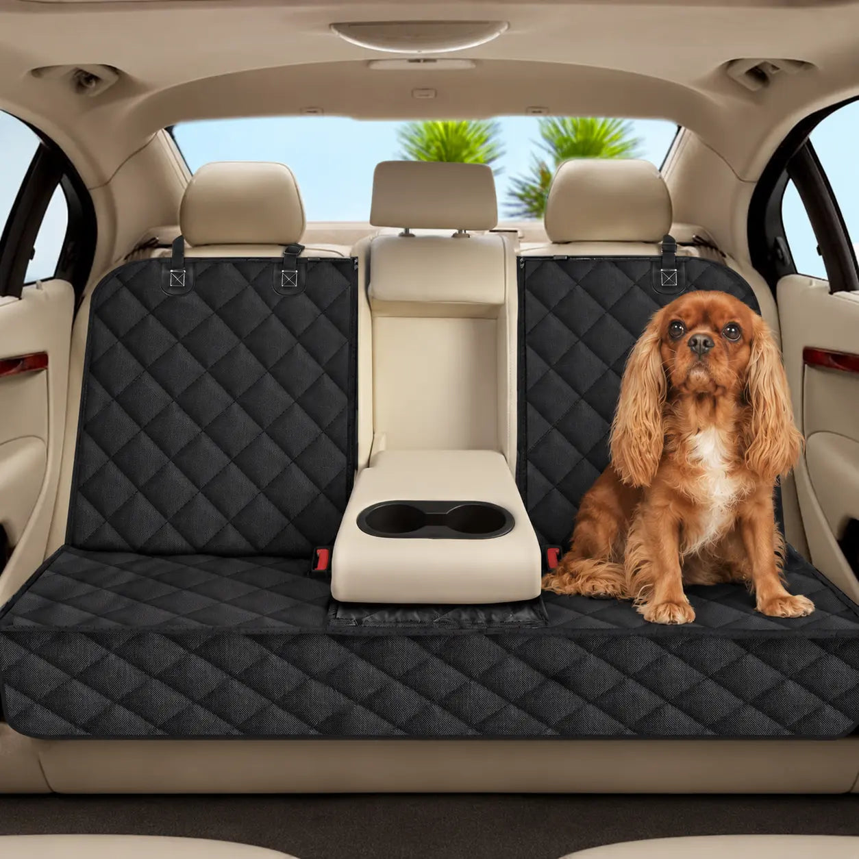 A spaniel on the black quilted rear-seat cover in a parked car