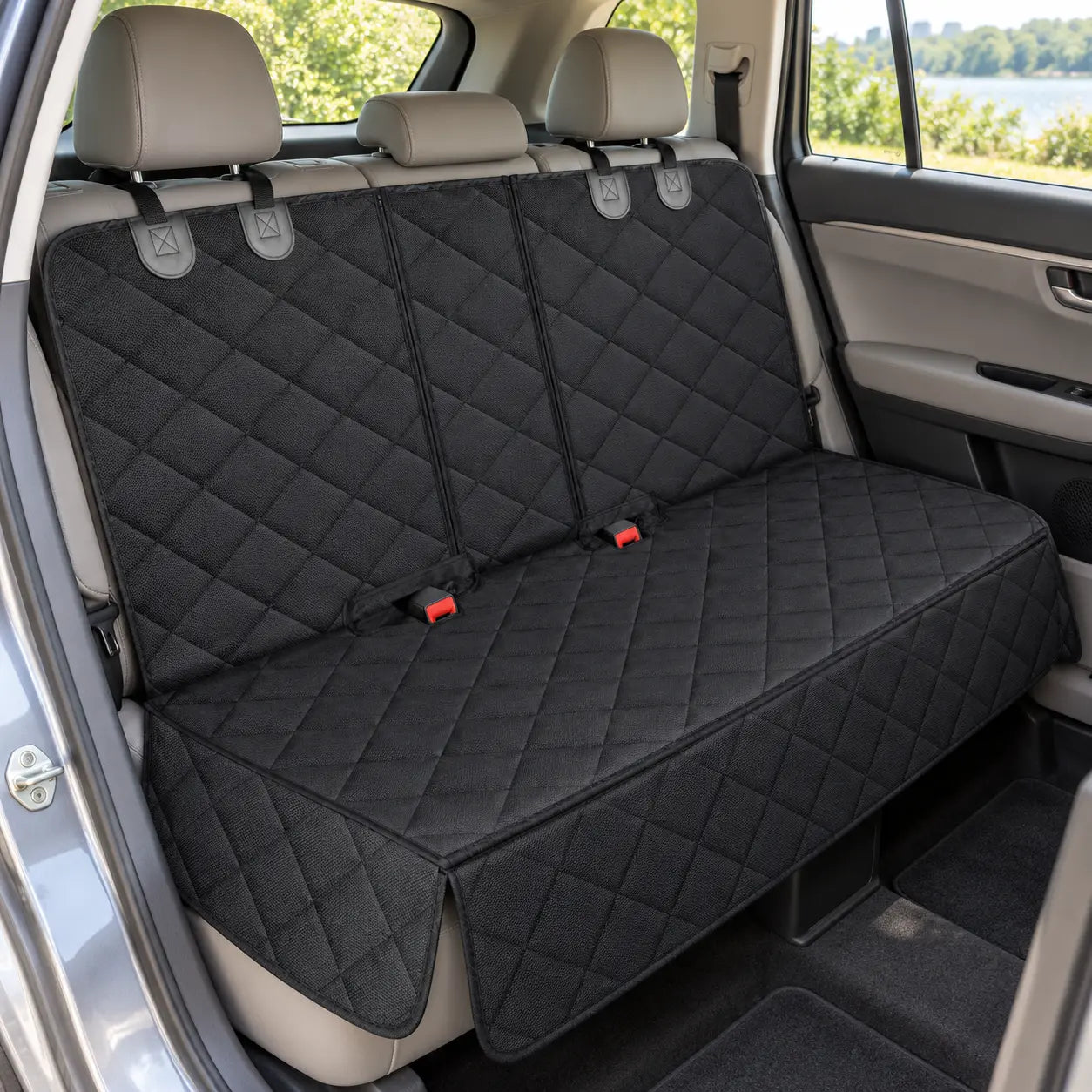 Black quilted rear-seat cover installed across a parked car’s rear bench
